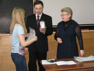 Инженер и преподаватель АСКОН-Западная Сибирь Дмитрий Яковенко вручает подарок одной из участниц конкурса